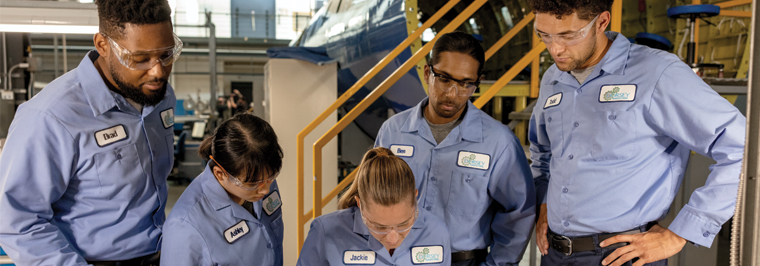 Team of five employees wearing matching work uniforms - blue work shirts with name and company emblems